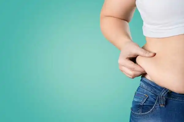 Image of woman pinching her love handles to show weight gain Worksop